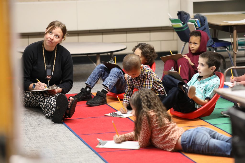 Teacher and students working on carpet